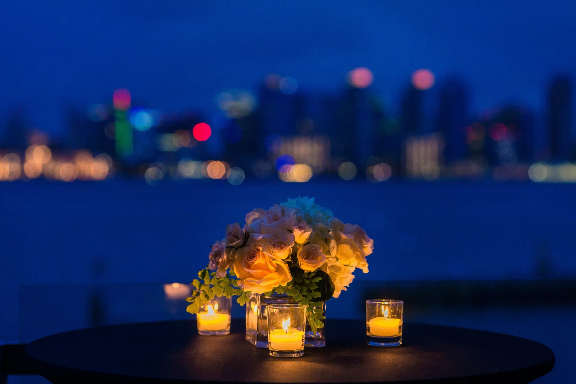 Romantic table setting with candles and roses at evening