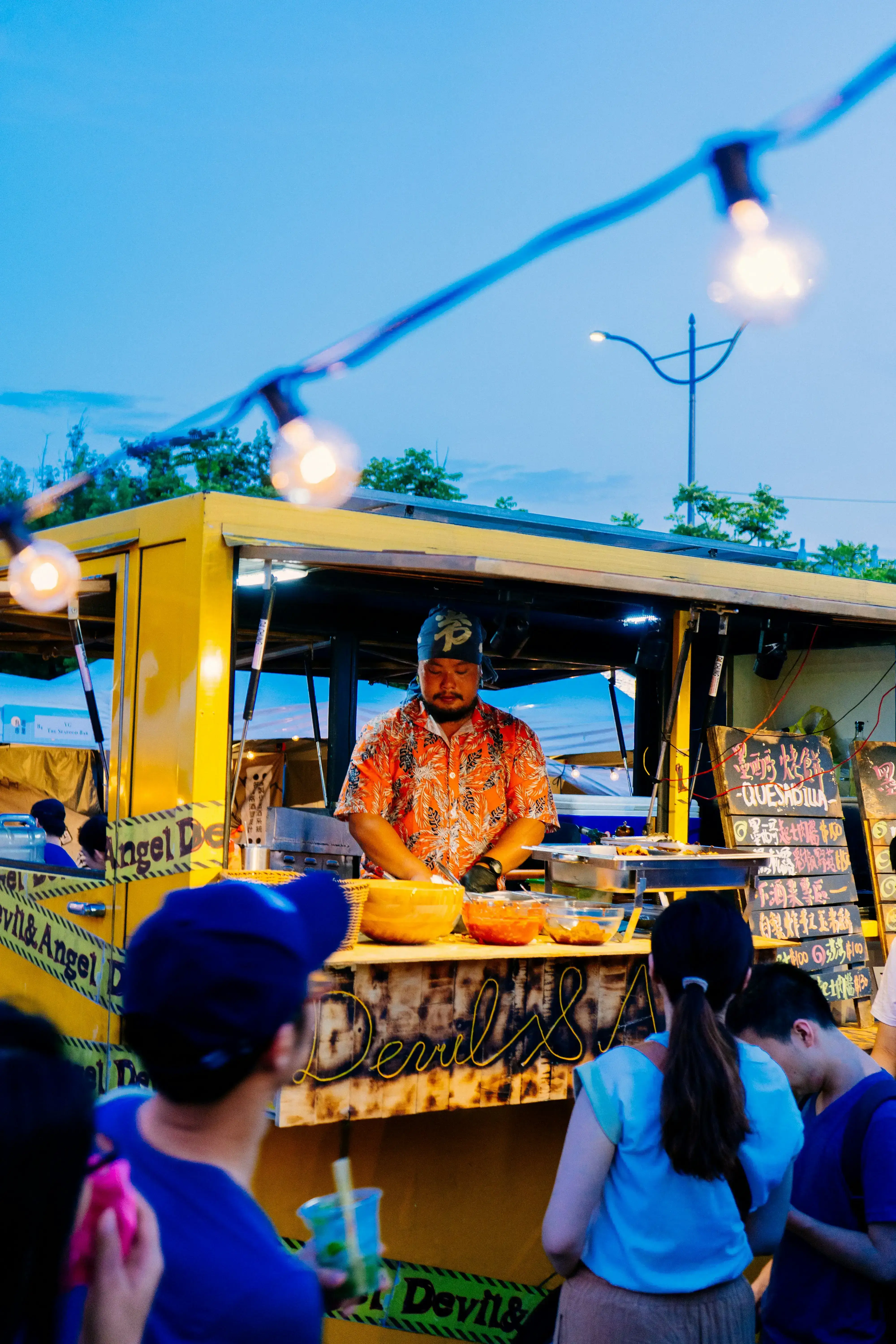 People queuing at food trucks during a festival