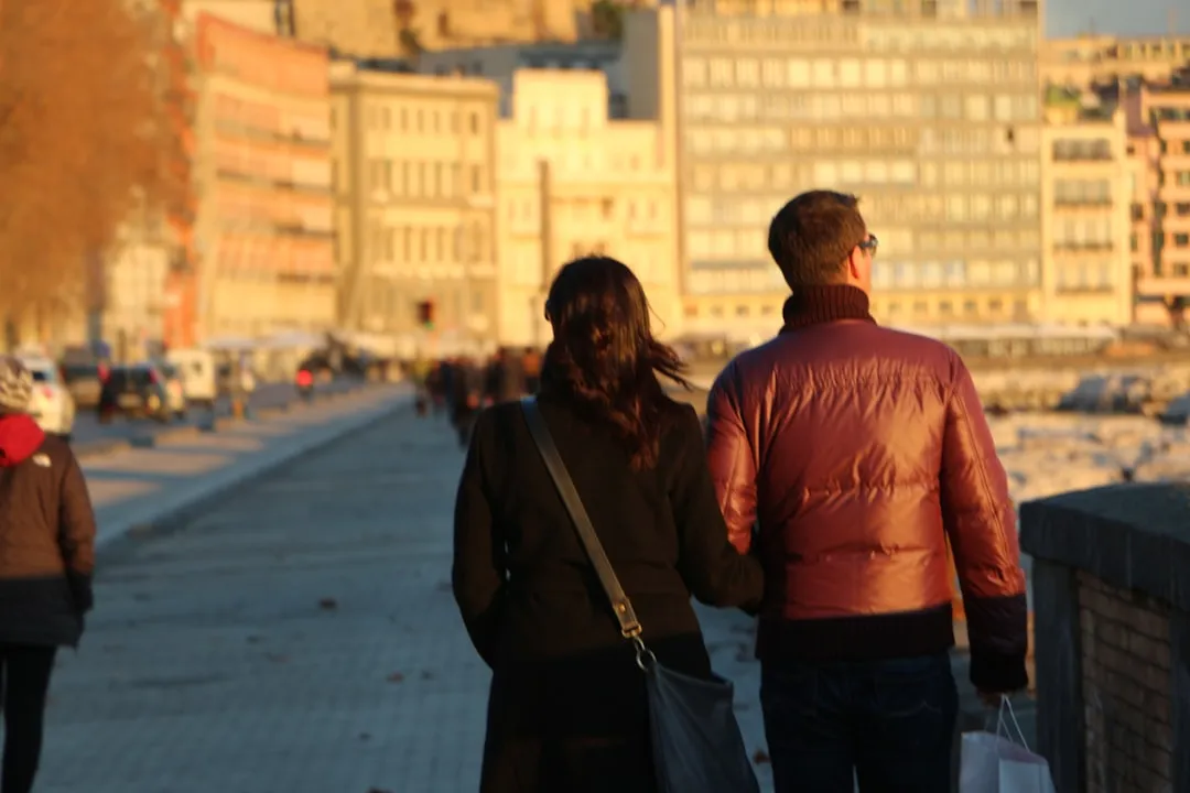 Couple walking together along a waterfront in warm golden light