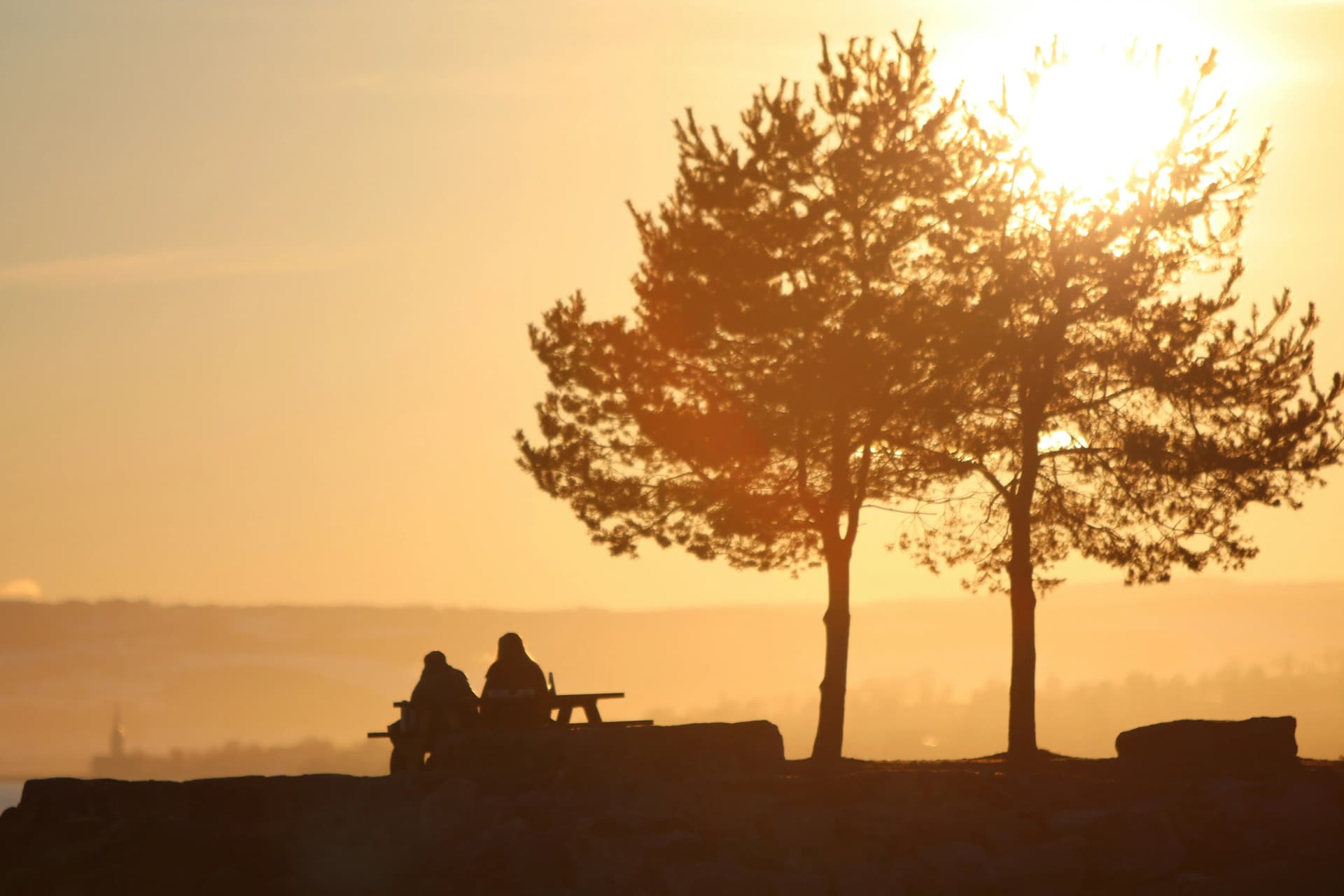 Couple sitting on a chair enjoying a romantic sunset