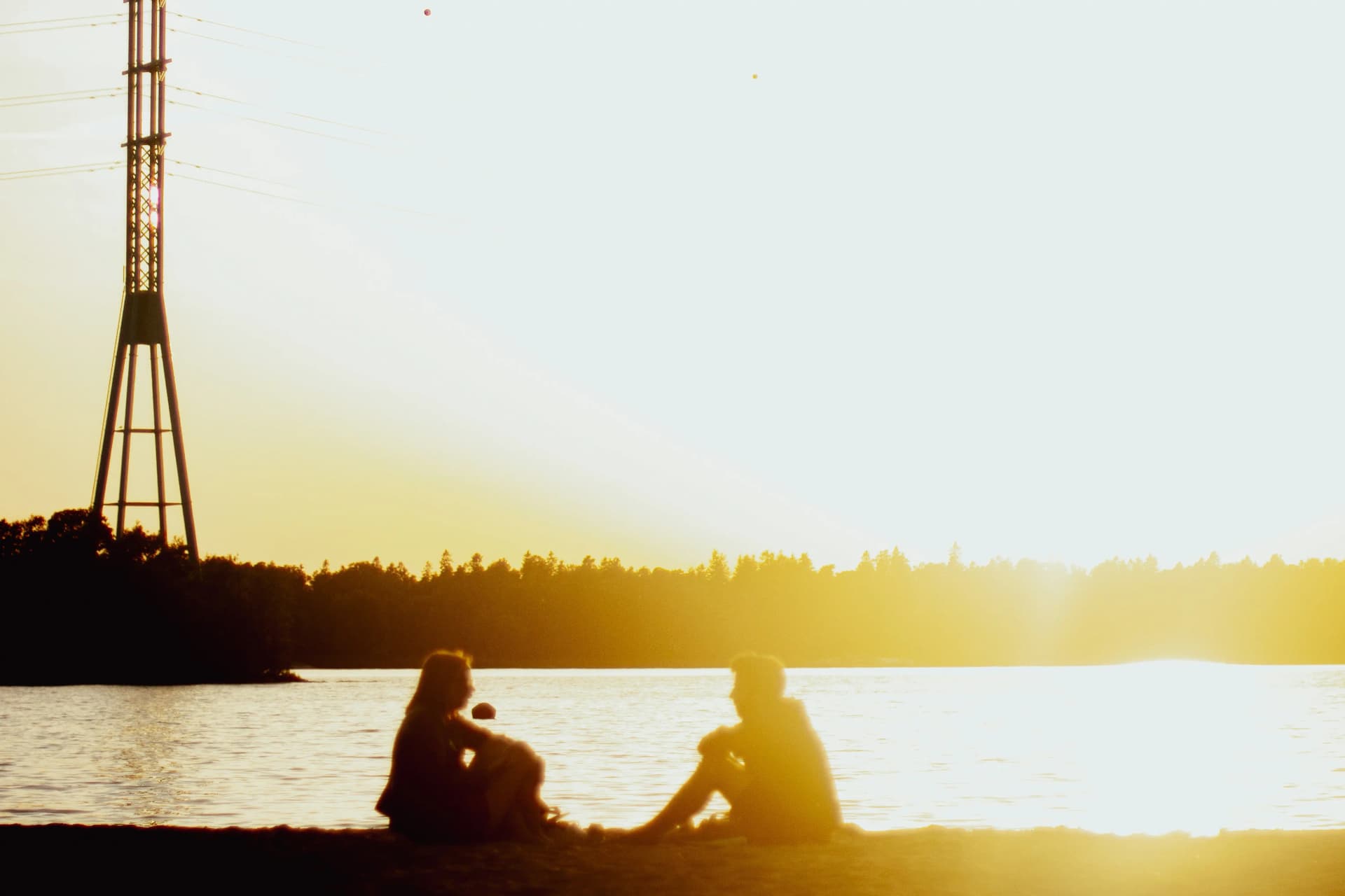 Couple sitting on beach watching the sunset together