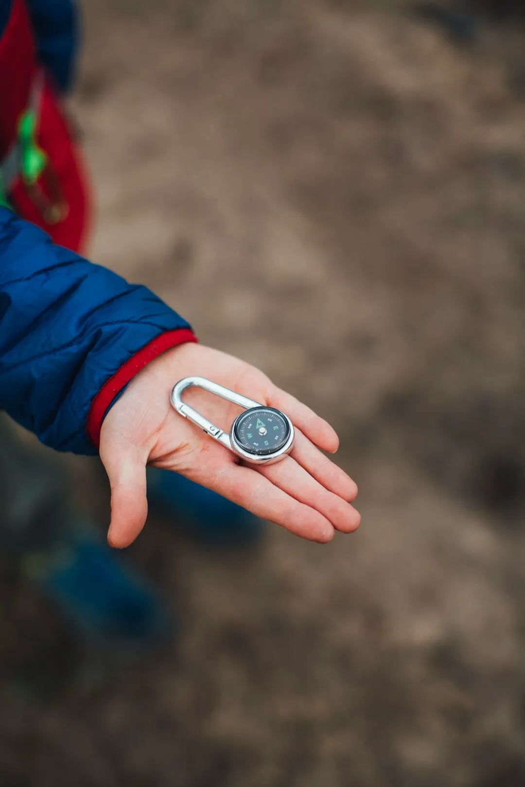 Person holding a compass while navigating outdoors