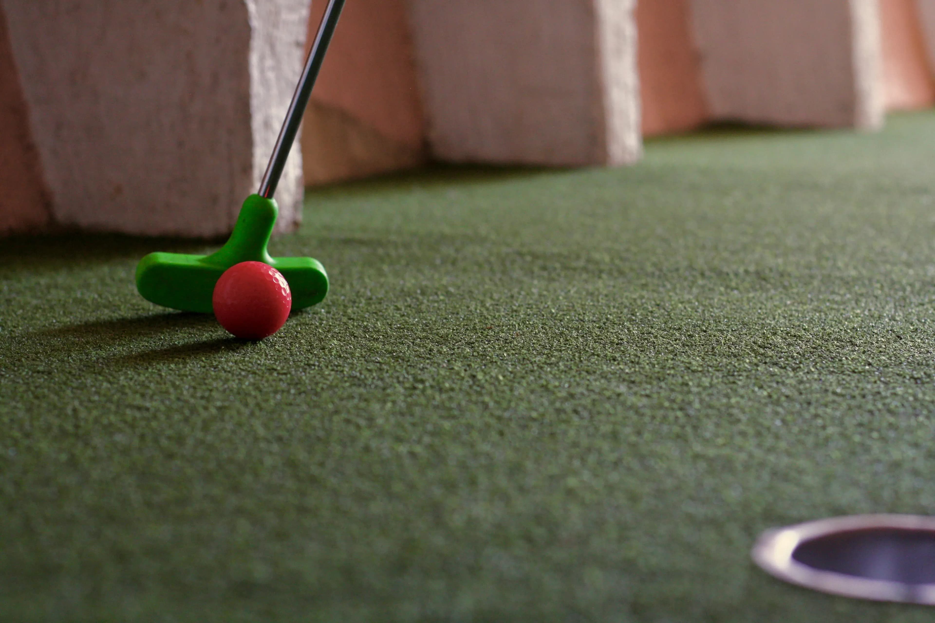 Mini golf ball on colorful course with obstacles