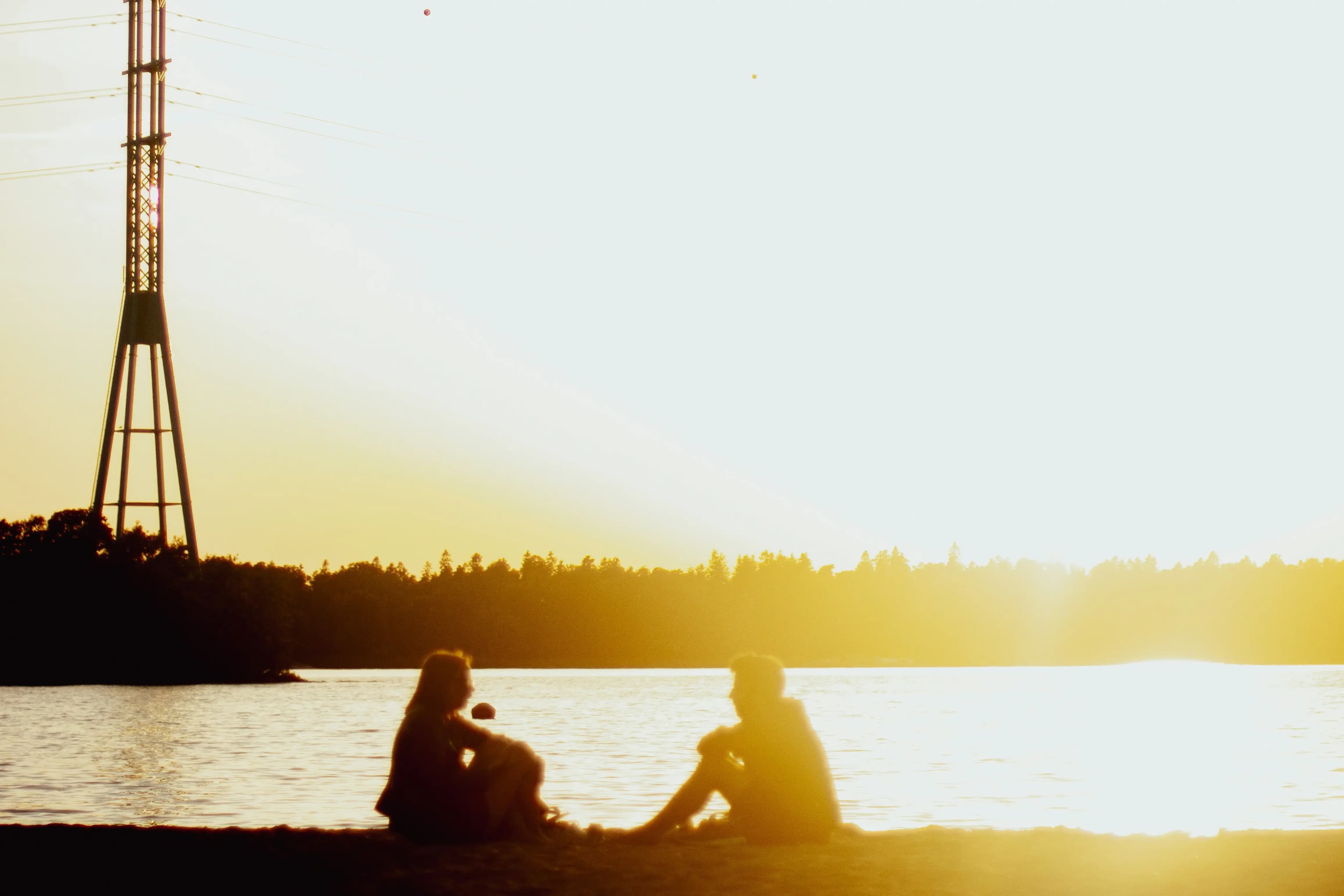Couple sitting on beach watching the sunset together